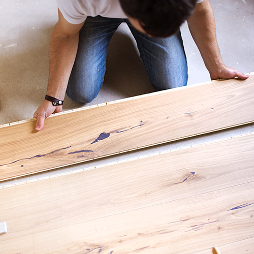 Technicien qui pose du parquet en bois